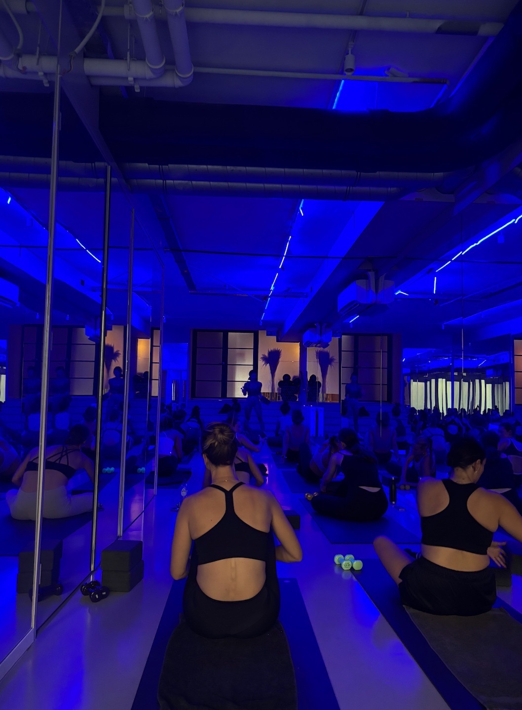 A full hot class at YOGI under blue light